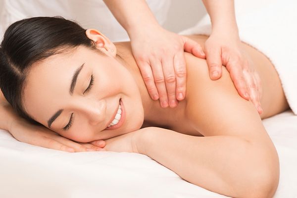 Full body massage session in a serene spa room.